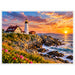 Portland Head Lighthouse in Cape Elizabeth, Maine, overlooking a rocky Atlantic coastline at sunset with colorful clouds, crashing ocean waves and pink coastal wildflowers.